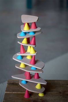 a wooden toy with several different colored cones on it's sides and one is upside down