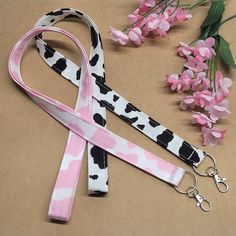 Show off your bovine style with these 'udderly' awesome pink and black cow print lanyards! Crafted from 100% cotton, these fabric lanyards are perfect for keeping your badge ID holder, keys, or keychain secure and fashionable. Get moo-ving and grab a set of these two lanyards today! Get these handmade, ready-to-ship lanyards at one great price!      Made with 100% Cotton premium characters Fabric.  This lanyard is approximately 21-21.5 inches (in loop form) and will easily fit around your neck.  The width is Approximately .75 inches. Silver hardware is sewn in so there is no breakaway. Includes Swivel Clip.  All Lanyards are made from Premium Cotton or Quilting Scrap Material so Patterns and Materials are limited.  Let's Be Friends!   tiktok.com/@craftyangiedesigns Cow Keychain, Strawberry Cow, Fabric Lanyard, Scrap Material, Key Lanyard, Black Cow, Id Holder, Badge Holders Lanyard, Cow Print