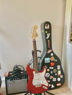 an electric guitar, amp and other musical instruments are sitting on the floor in front of a white wall