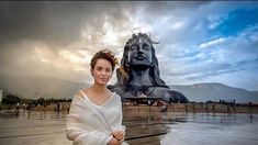 a woman standing in front of a large statue