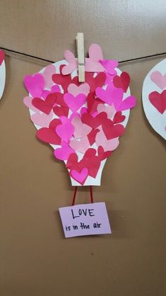 valentine's day decorations with paper hearts hanging from clothes pins