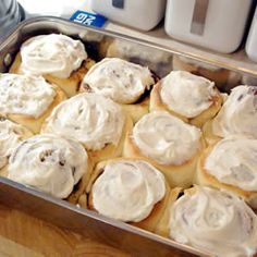 a pan filled with rolls covered in white icing