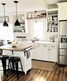 a kitchen with wooden floors and white cabinets