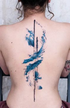 the back of a woman's body is covered in blue ink and has an abstract design on it