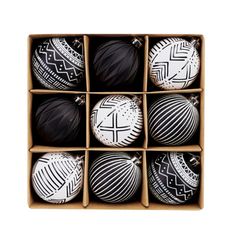 six black and white ornaments in a cardboard box