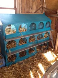 an old blue stove sitting inside of a barn filled with lots of hay and straw