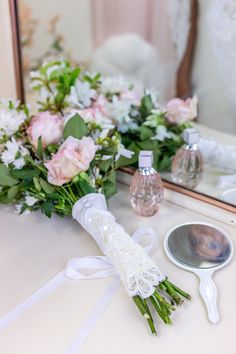 a bouquet of flowers sitting on top of a table next to a mirror