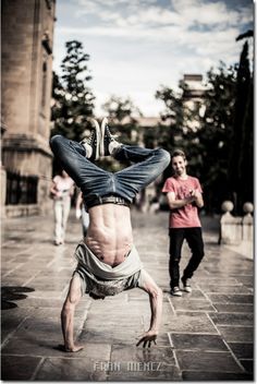 a man doing a handstand on the street