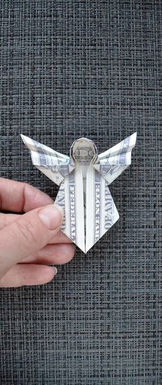 a person holding an origami airplane made out of money