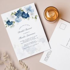 the wedding stationery is laid out next to an envelope and a glass of wine