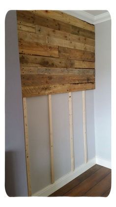 an empty room with wood planks on the wall and hard wood flooring in it