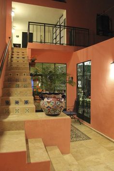 a staircase leading up to the second floor in a house with pink walls and tile floors