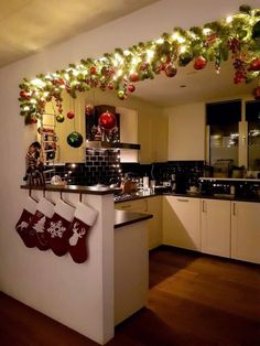 a kitchen decorated for christmas with stockings hanging from the ceiling and decorations on the counter