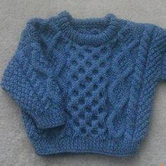 a blue knitted sweater laying on the floor