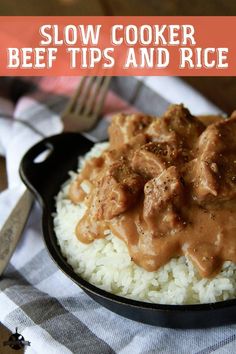 a skillet filled with rice and meat covered in gravy next to a fork