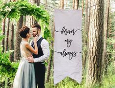 a bride and groom standing in the woods next to a forest sign that says, i love my alwayss