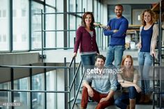 group of people standing on stairs in an office building, smiling at the camera stock photo