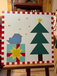 a wooden easel decorated with christmas trees and birds