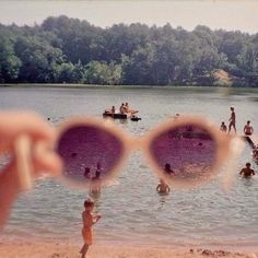 people are swimming in the water with their sunglasses reflecting them into the camera's lens