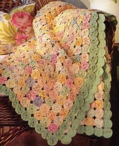 a crocheted blanket sitting on top of a wicker chair