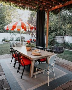 an outdoor dining area with table, chairs and umbrella