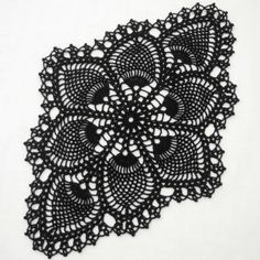 an intricate black doily on a white background