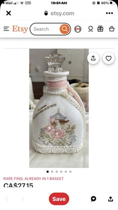 a white bottle with pink roses on it and a crown on the top is for sale