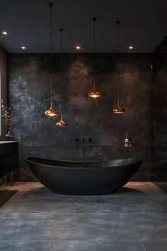 a large black bath tub sitting under three lights