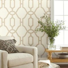 a living room scene with focus on the sofa and wallpaper that has a trellis pattern