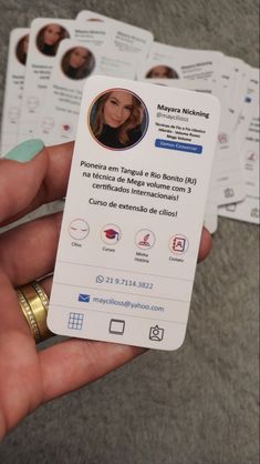 a person holding up some business cards in their left hand, with the same card on it's side