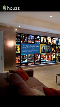 a living room filled with furniture next to a large window covered in movie posters on the wall