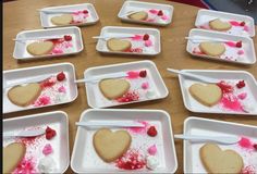 some heart shaped cookies on white plates with pink sprinkles