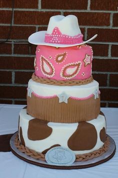 a three tiered cake decorated with pink, brown and white cowhides on top