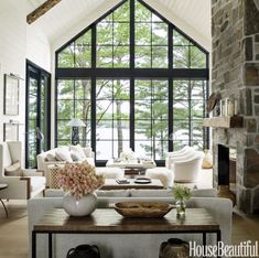 a living room filled with furniture and a large window covered in lots of natural light