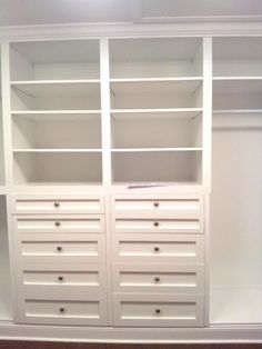 an empty white closet with drawers and shelves