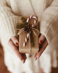 a person holding a wrapped present with candy canes