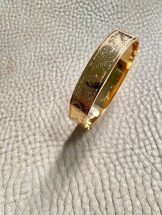 Made in 1962 - Wide Hinged Bangle in 18k gold - Etched Curls Pattern - Stockholm, Sweden - Size 7 Stunning vintage hinged bangle crafted in 18k yellow gold. Bangle was made in 1962 by maker GFP active 1945-1968. Bracelet has full Swedish hallmarks for maker, year, location and gold purity. By hand, the goldsmith etched a wonderful swirling curl pattern on one side of the bangle and polished the other side - you can wear her either way - a two in one! She is oval shaped measuring 7 inches inside Luxury Cuff Bracelet With 17 Jewels For Anniversary, Ceremonial Luxury Gold Jubilee Bracelet, Hallmarked Yellow Gold Cuff Bracelet For Formal Occasions, Formal Hallmarked Yellow Gold Cuff Bracelet, Luxury 14k Stamped Bangle Gift, Formal Yellow Gold Hallmarked Cuff Bracelet, Formal Heirloom Yellow Gold Cuff Bracelet, Luxury Hallmarked Cuff Bracelet For Anniversary, Luxury Engraved Round Cuff Bracelet