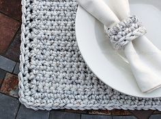 a white plate sitting on top of a table next to a crocheted place mat