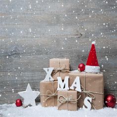 a christmas card with presents on it and the words xmas spelled in white letters