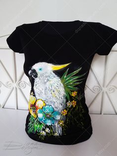 a black shirt with a white parrot on it's chest and flowers around the neck