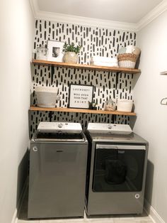 a washer and dryer in a laundry room with black and white wallpaper