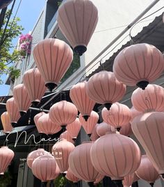 many pink lanterns hanging from the side of a building