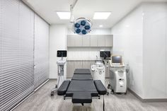 a hospital room with medical equipment in the background and lights on above it that are hanging from the ceiling