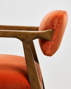 an orange chair with a wooden frame and cushion