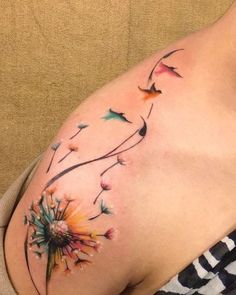 a woman's stomach with a dandelion tattoo on it