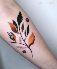 a colorful tattoo on the arm of a woman's leg with an orange and black feather