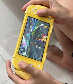 a person holding a yellow cell phone with mario kart game on it's screen