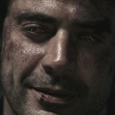 a close up of a man wearing a suit and tie with blood all over his face