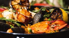 a bowl filled with seafood and vegetables on top of a table