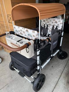 a cart with two coolers on it in front of cardboard boxes and other items